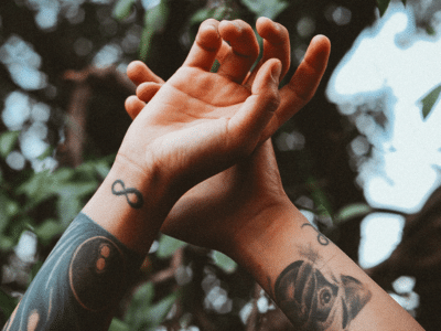 tattoo pflege zwei tattowierte arme in die Luft gestreckt